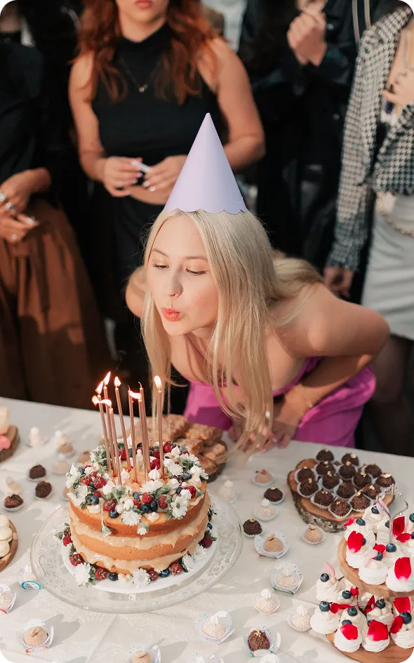Ragazza che spegne le candeline sulla torta di compleanno
